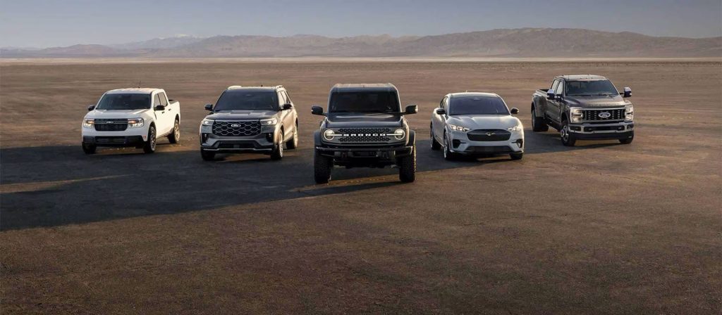 Five Ford vehicles parked in a desert.